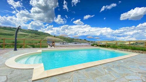 una piscina en un patio con un cielo azul en Le Cornici - Cascina di Charme en Diano dʼAlba