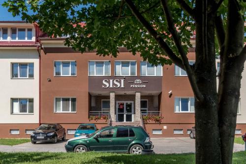 a green car parked in front of a building at SISI Pension in Púchov