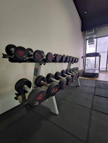 a gym with rows of dumbbells on a wall at Kuching Galacity Apartment in Kuching