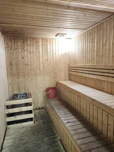 a sauna with wooden shelves and a red bucket at Kuching Galacity Apartment in Kuching
