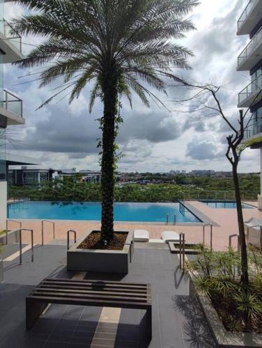a palm tree sitting next to a swimming pool at Kuching Galacity Apartment in Kuching