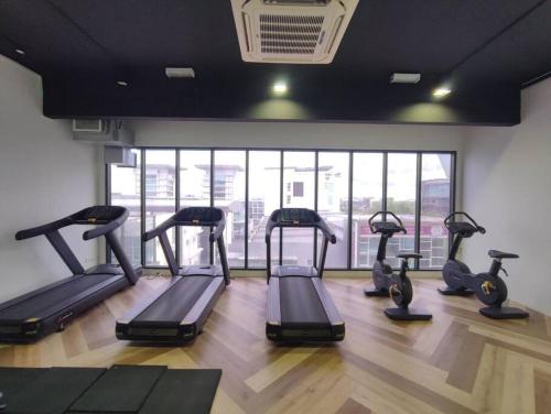 a group of treadmills in a gym with a large window at Kuching Galacity Apartment in Kuching