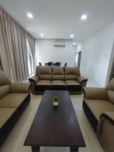 a living room with couches and a coffee table at Kuching Galacity Apartment in Kuching