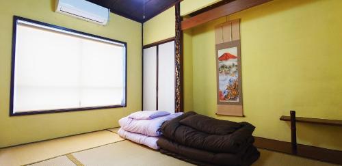 a room with a couch in a room with a window at ゲストハウス 編湊 in Nakaminato