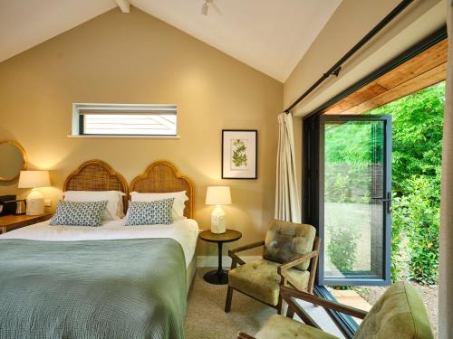sypialnia z łóżkiem, krzesłem i oknem w obiekcie The Weeping Willow w mieście Bury St Edmunds