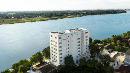 an aerial view of a white building next to a river at Riverfront Apartments Vientiane in Vientiane