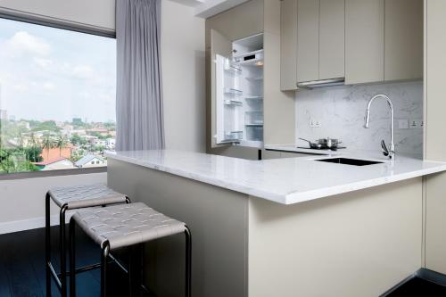 a white kitchen with a counter and a window at Riverfront Apartments Vientiane in Vientiane