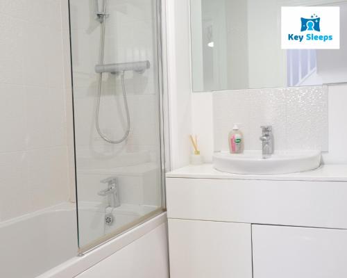 y baño blanco con lavabo y ducha. en Large House By Keysleeps Short Lets Northampton M1 With Free Parking Contractors Leisure, en Great Billing