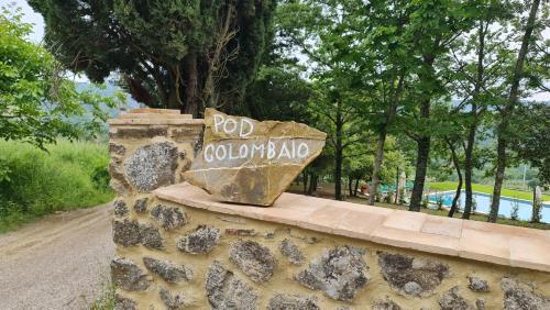 a stone wall with a sign that reads red colombia at Podere Colombaio - Bucaneve in Radicofani