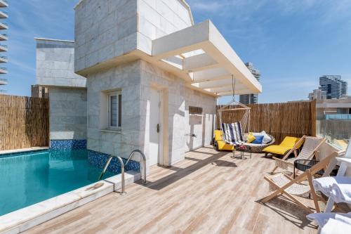 a house with a swimming pool and a patio at Boutique Villa with Rooftop Pool in Netanya