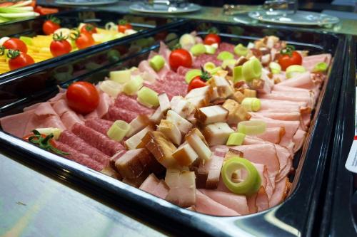 eine Auswahl an Fleisch und Gemüse auf einem Buffet in der Unterkunft Hotel Soimul in Poiana Brașov