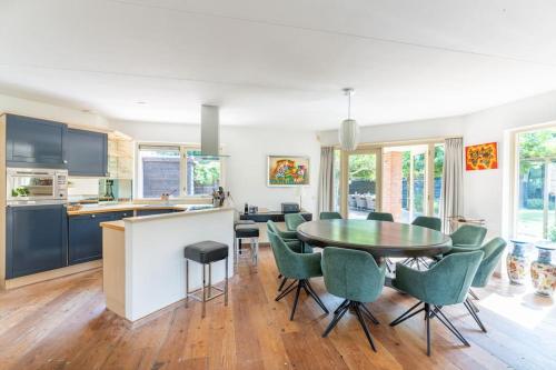 eine Küche und ein Esszimmer mit einem Tisch und Stühlen in der Unterkunft Family Villa in Forest with shared pool & Wellness in Zeewolde