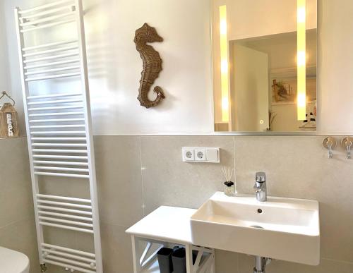 ein Badezimmer mit einem Waschbecken und einem Seepferdchen an der Wand in der Unterkunft MEI71 Ferienwohnung Strandlust F in Niendorf