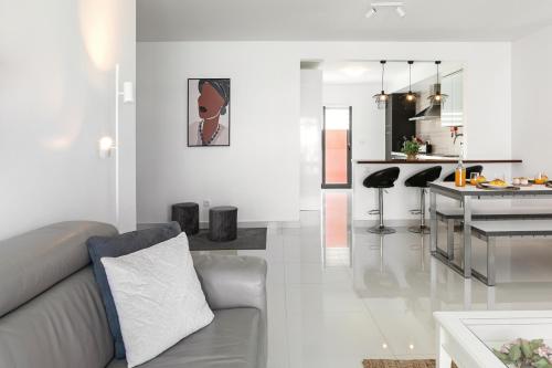a white living room with a couch and a kitchen at Baleal Deluxe Flat in Ferrel