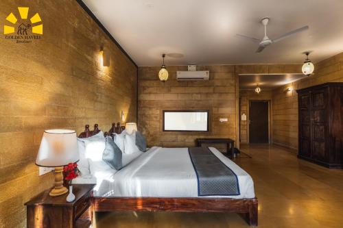 a bedroom with a bed and a tv on a wall at Hotel Golden Haveli in Jaisalmer