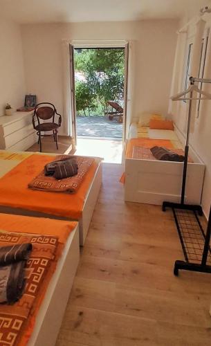 two beds in a room with a window at Apartman Bonkovic in Gdinj