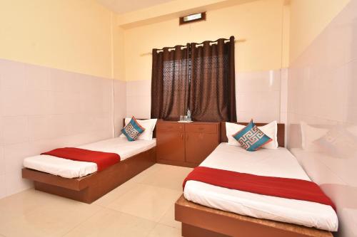 a bedroom with two beds and a window at HOTEL KANNUR CAPITAL CALTEX in Kannur