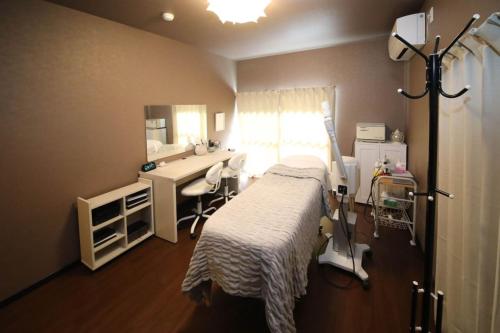 a hospital room with a bed and a desk at さきみや in Goto
