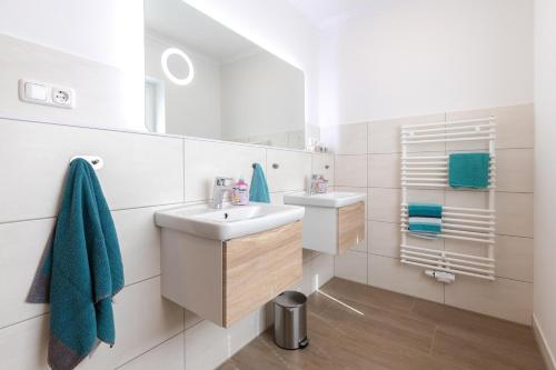La salle de bains blanche est pourvue d'un lavabo et d'un miroir. dans l'établissement Ferienhaus Südheide 2.0 Natürlich!, à Hermannsburg