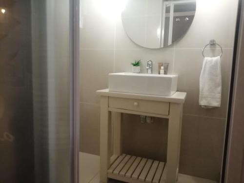 y baño con lavabo blanco y espejo. en Seaforth Guesthouse, en East London
