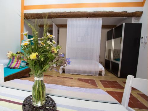 a vase of flowers on a table in a room at La Comédie de Pézenas - Appartements in Pézenas