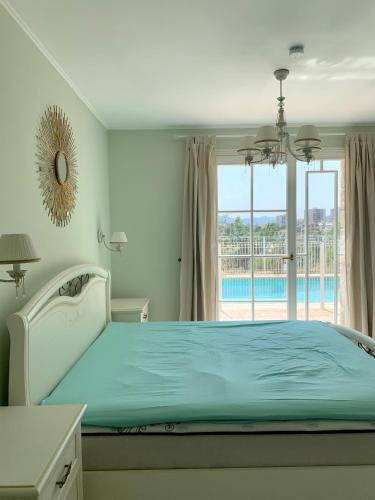 une chambre avec un lit avec vue sur une piscine dans l'établissement Maison de ville dans la Villa Brise des Pins, au Cannet