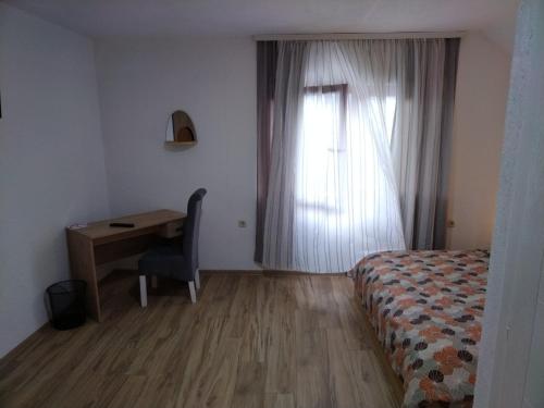 a bedroom with a bed and a desk and a window at Nice view-Plitvice in Korenica