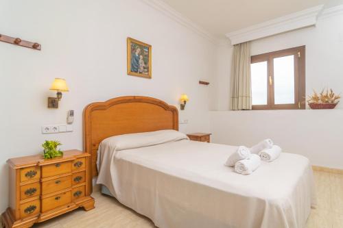 a bedroom with a bed and a dresser and a window at Can Cama Rotja in Inca