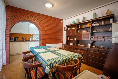 een keuken met een tafel en een bakstenen muur bij Olivia Apartment House in Balatonboglár