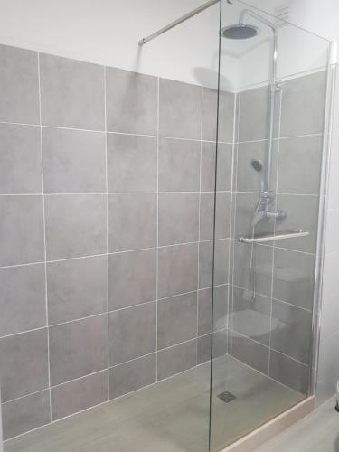 um chuveiro com uma porta de vidro na casa de banho em Apartamento Cristino na Praia da Luz