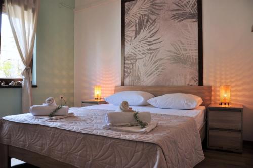 una camera da letto con un grande letto con asciugamani di Jungle & Sea Boxavia a Božava