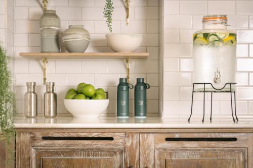 a kitchen counter with bottles and a bowl of apples at Gleneagles Townhouse in Edinburgh