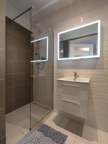a bathroom with a shower and a sink and a mirror at Pokoje Gościnne Majkowscy in Białogóra