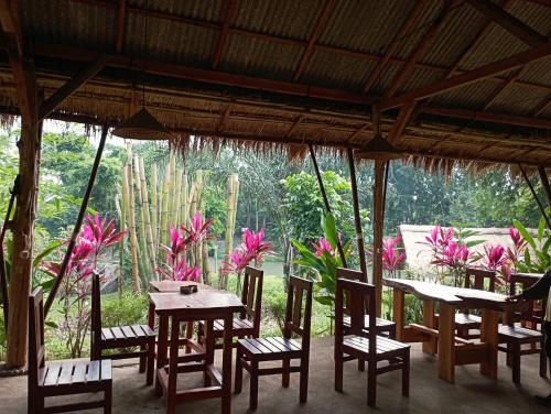 a dining room with tables and chairs and plants at Sumilir Riverside Retreat in Banyuwangi