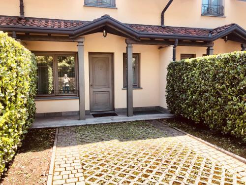 a house with a front door and a hedge at MOTEL Malpensa INN & Hotel-Airport in Tornavento