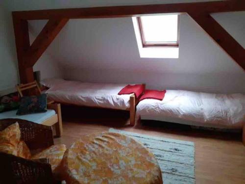a attic room with two beds and a window at Komfortowy dom w lesie in Miedzichowo