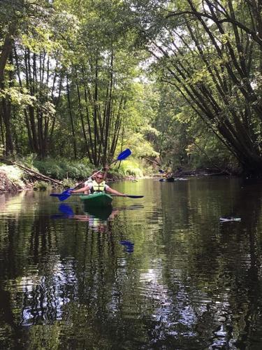 a couple of people in a canoe on a river at Komfortowy dom w lesie in Miedzichowo