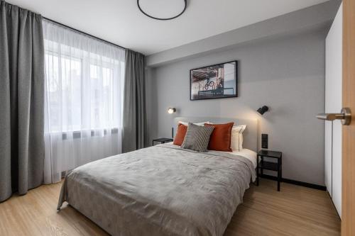 un dormitorio con una cama y una ventana grande en Balcia Residence, en Riga
