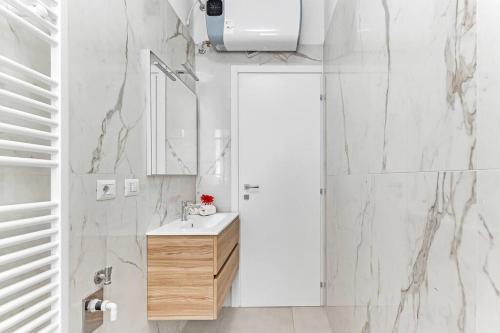 een witte badkamer met een wastafel en een spiegel bij Alessia's Flat - Caroli in Milaan