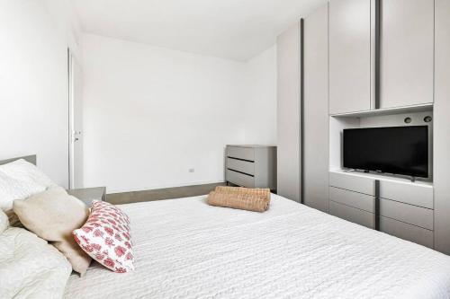een witte slaapkamer met een bed en een televisie bij Alessia's Flat - Caroli in Milaan