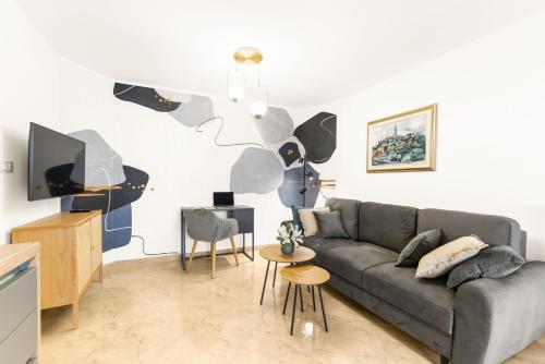 uma sala de estar com um sofá e uma televisão em Apartments Villa Ana em Porec