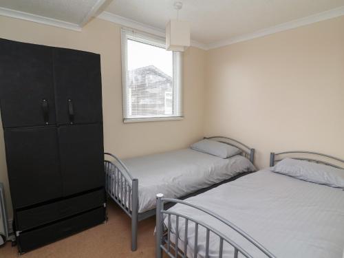 une chambre avec deux lits jumeaux et une fenêtre dans l'établissement Swiss Cottage, à Bridlington