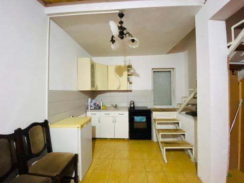 a kitchen with white cabinets and a table and chairs at Villat Bardhoshi in Mitrovicë