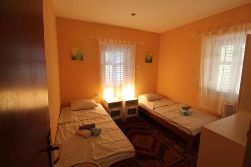two beds in a room with orange walls and windows at Holiday house with a parking space Rudina, Hvar - 18333 in Stari Grad