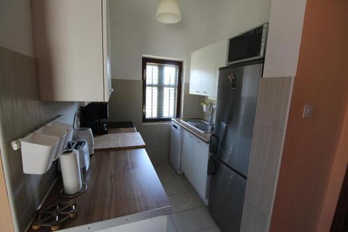 a kitchen with white cabinets and a black refrigerator at Holiday house with a parking space Rudina, Hvar - 18333 in Stari Grad