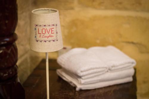a sock on a table next to a stack of towels at The Burrow Guest House in Tarxien