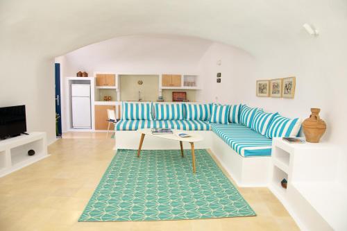 a living room with a blue and white couch and a rug at Amphora Villas Santorini Akrotiri in Akrotiri