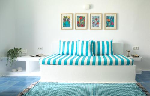 a couch with blue and white stripes in a room at Amphora Villas Santorini Akrotiri in Akrotiri