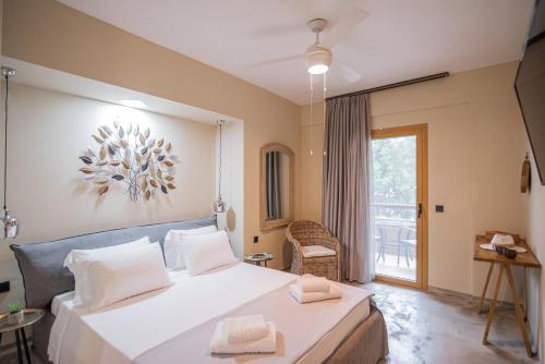 una camera da letto con un grande letto bianco e una finestra di Pefkon Suites ad Áfitos