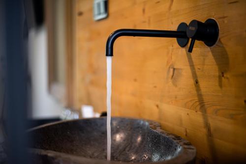 a stream of water coming from a faucet over a sink at Pefkon Suites in Afitos